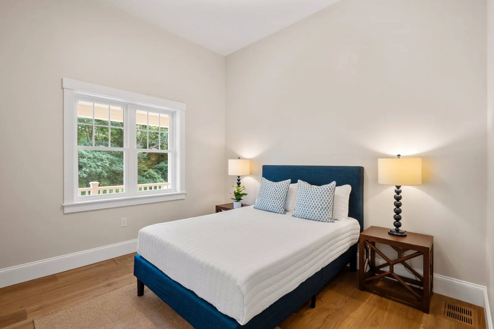 Bedroom with navy upholstered bed and two windows