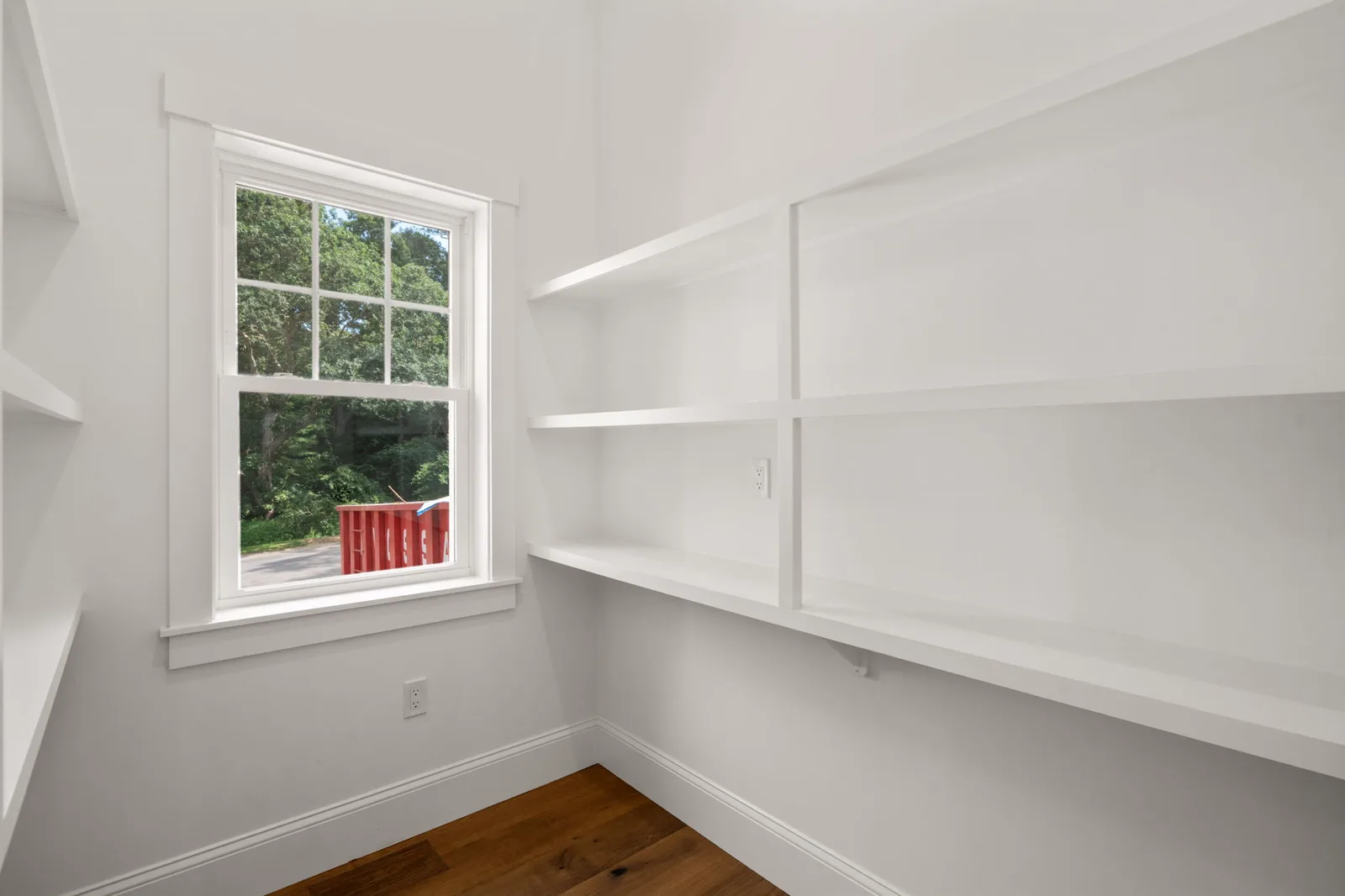Walk-in pantry with custom shelving and a window