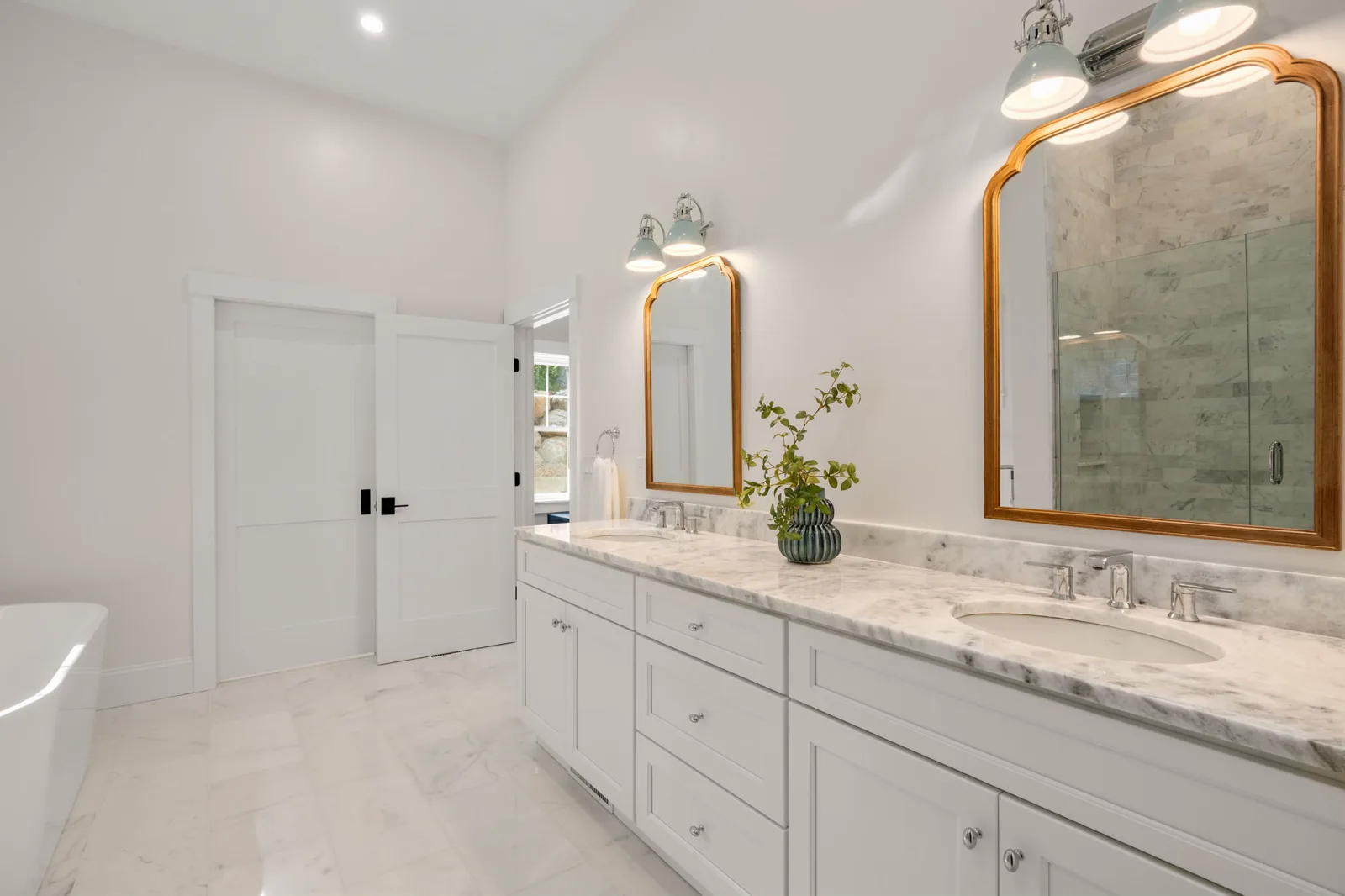 Freestanding tub beside the glass shower in the primary bath