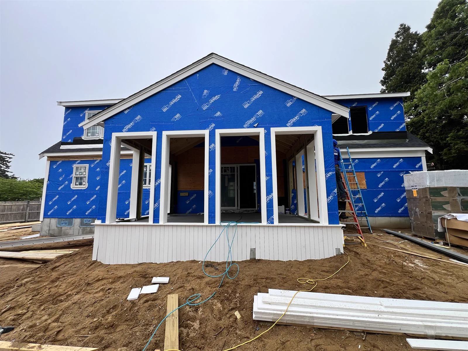 New home framed and wrapped, with a farmer's porch, replacing a torn-down cape in Harwich Port