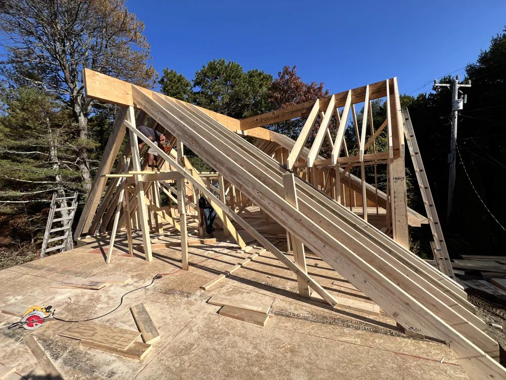 Roof trusses being set on the framed garage and addition