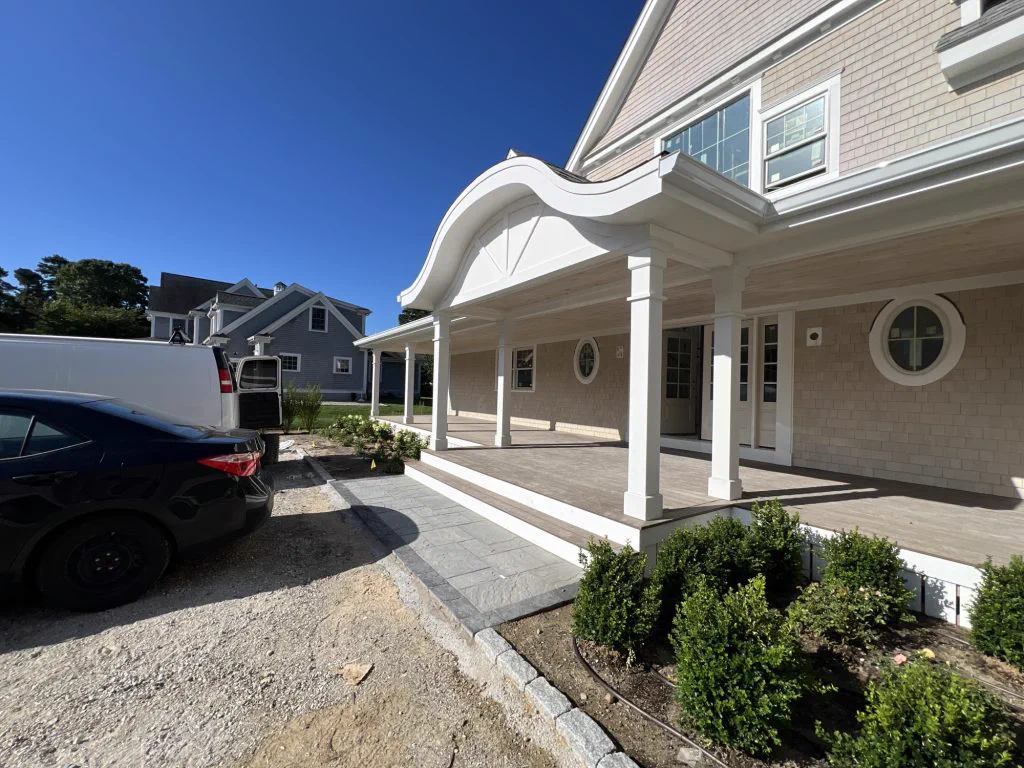 Farmer's porch and arched entry on a new shingle-style home in Sandwich, MA